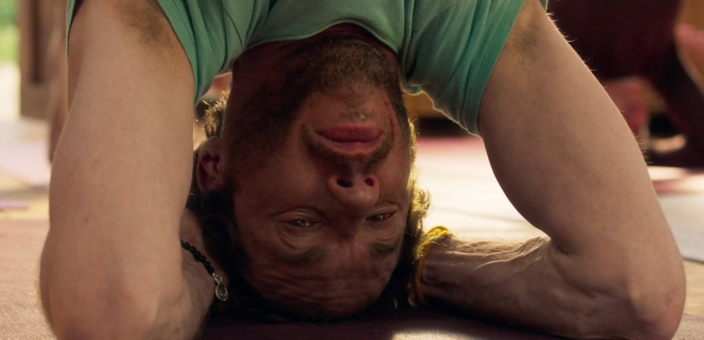 A scene from La Práctica (2023) showing a group of people in a yoga class, with several participants engaged in various yoga poses on mats in a serene, well-lit studio.